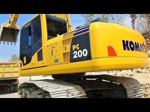 Komatsu PC200-8 Excavator Loading Limestone Into Dump Truck On Road Construction Site