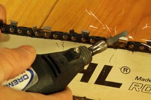 Sharpening a chainsaw blade with a Dremel rotary tool.